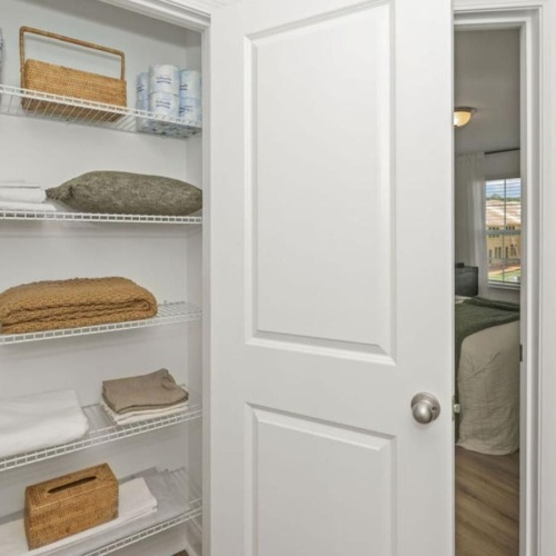a white closet with a basket and a basket on it