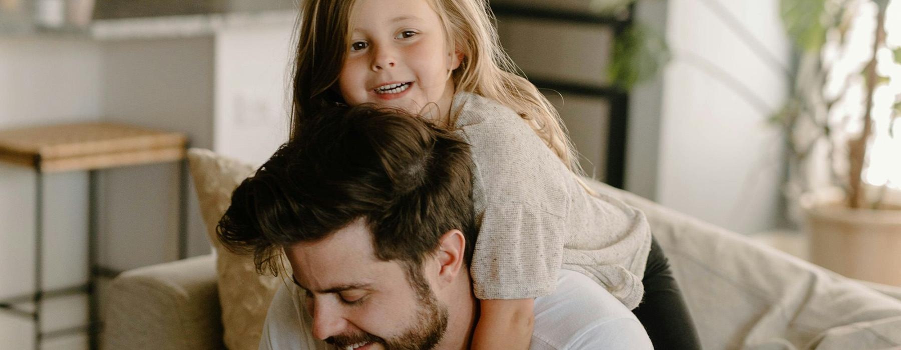 A girl hugging her father on a couch