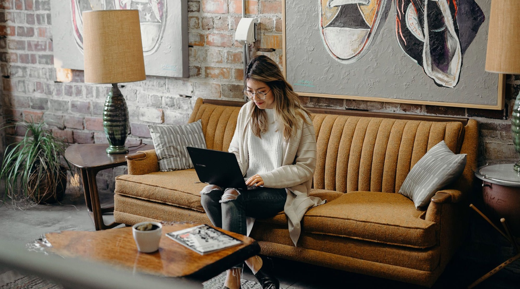 a woman typing on her laptop on a sofa